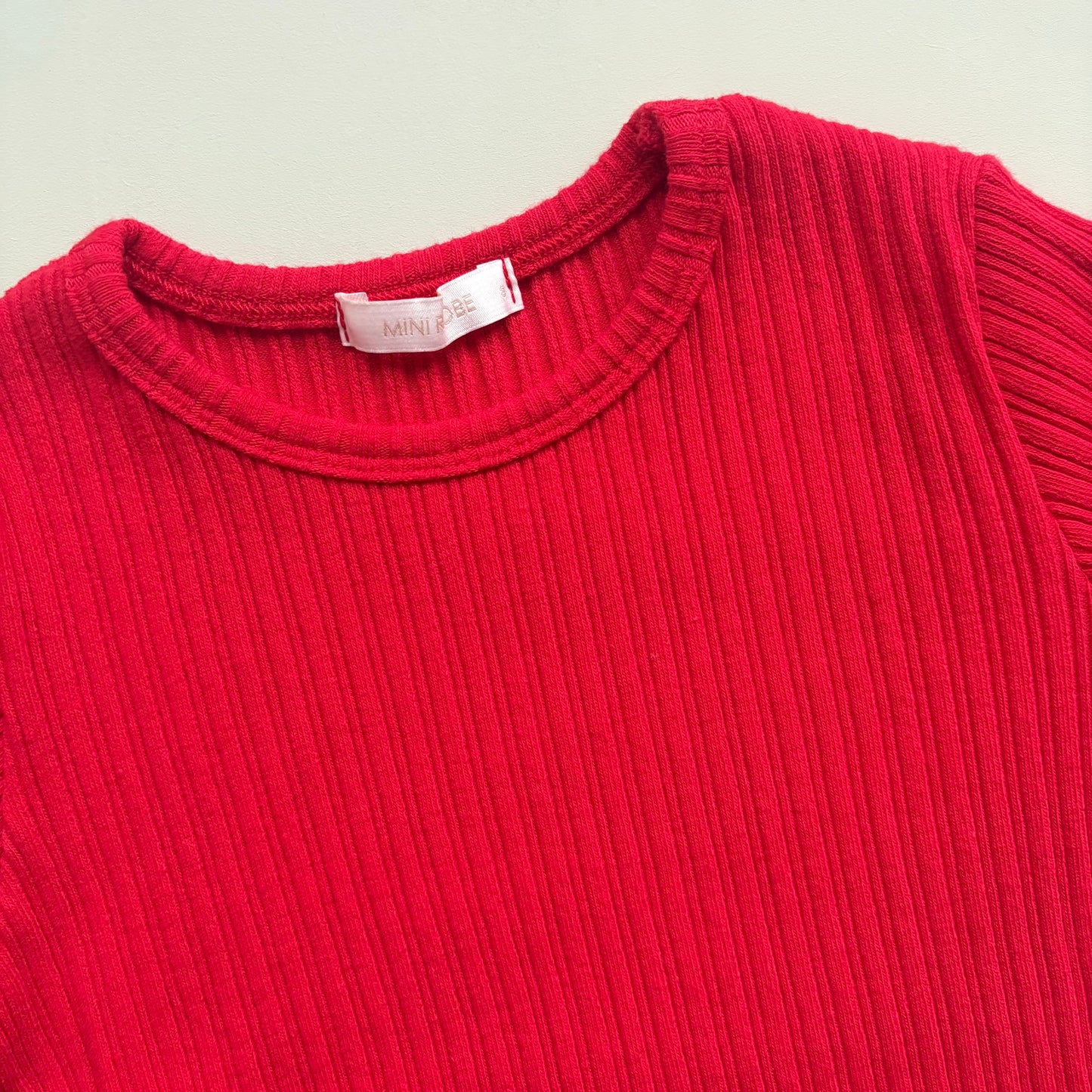close up of ribbed texture and neckline on red long sleeve t shirt
