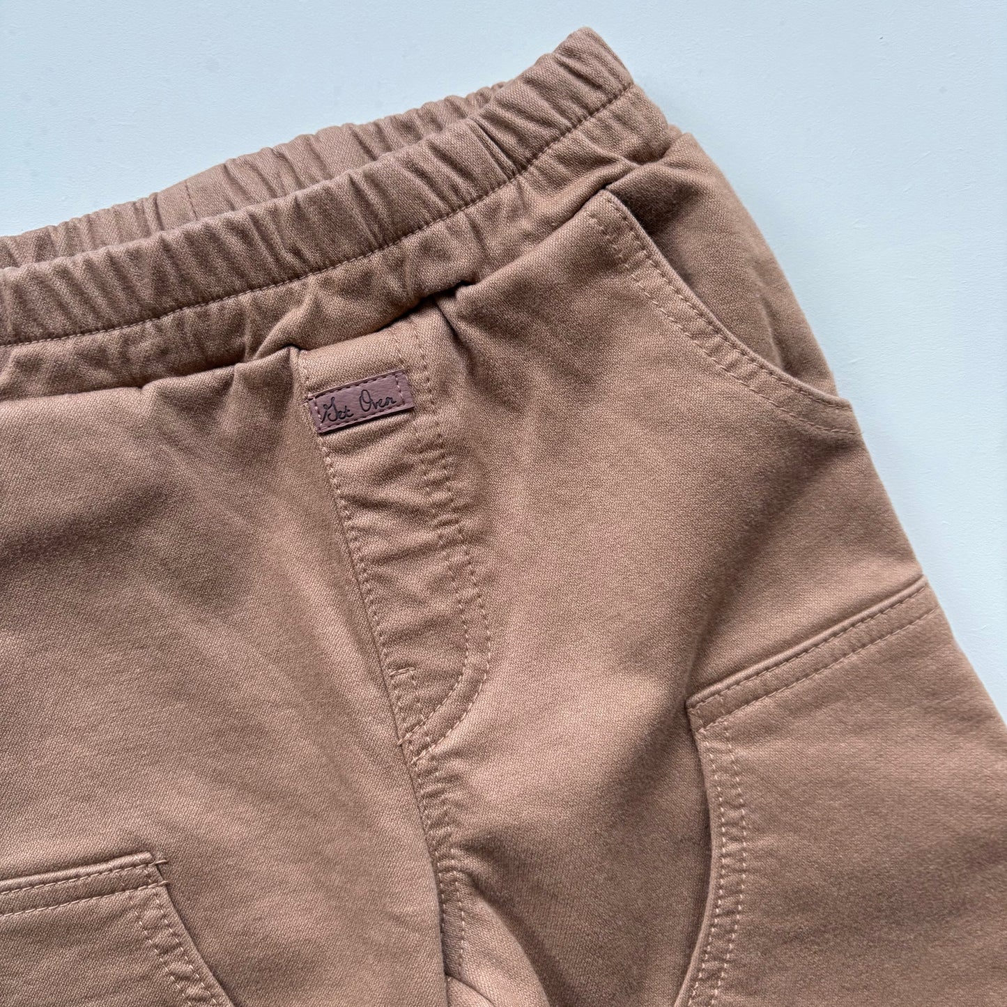 close up of children's chore pants with small faux leather label - Village Concept Store