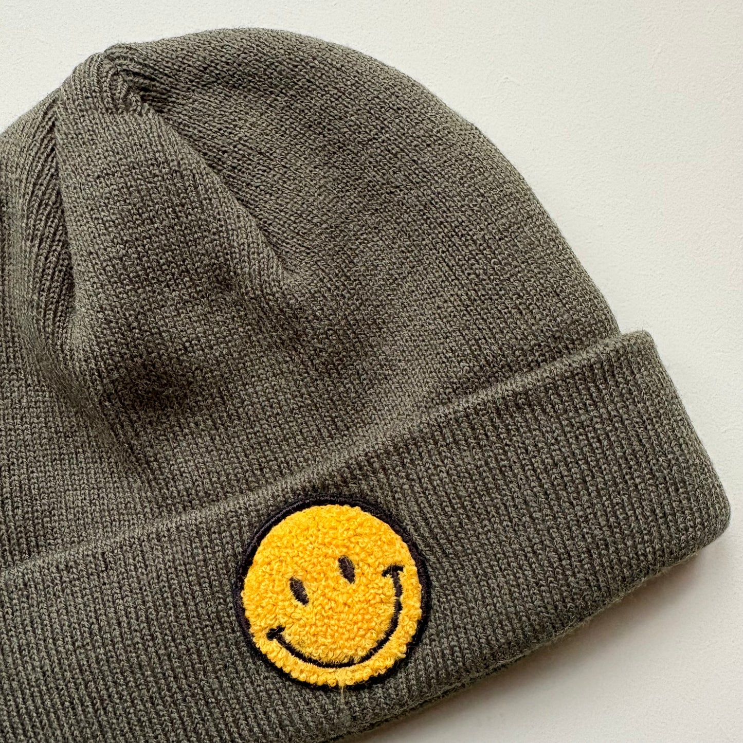 yellow embroidered smiley face detail on knit beanie