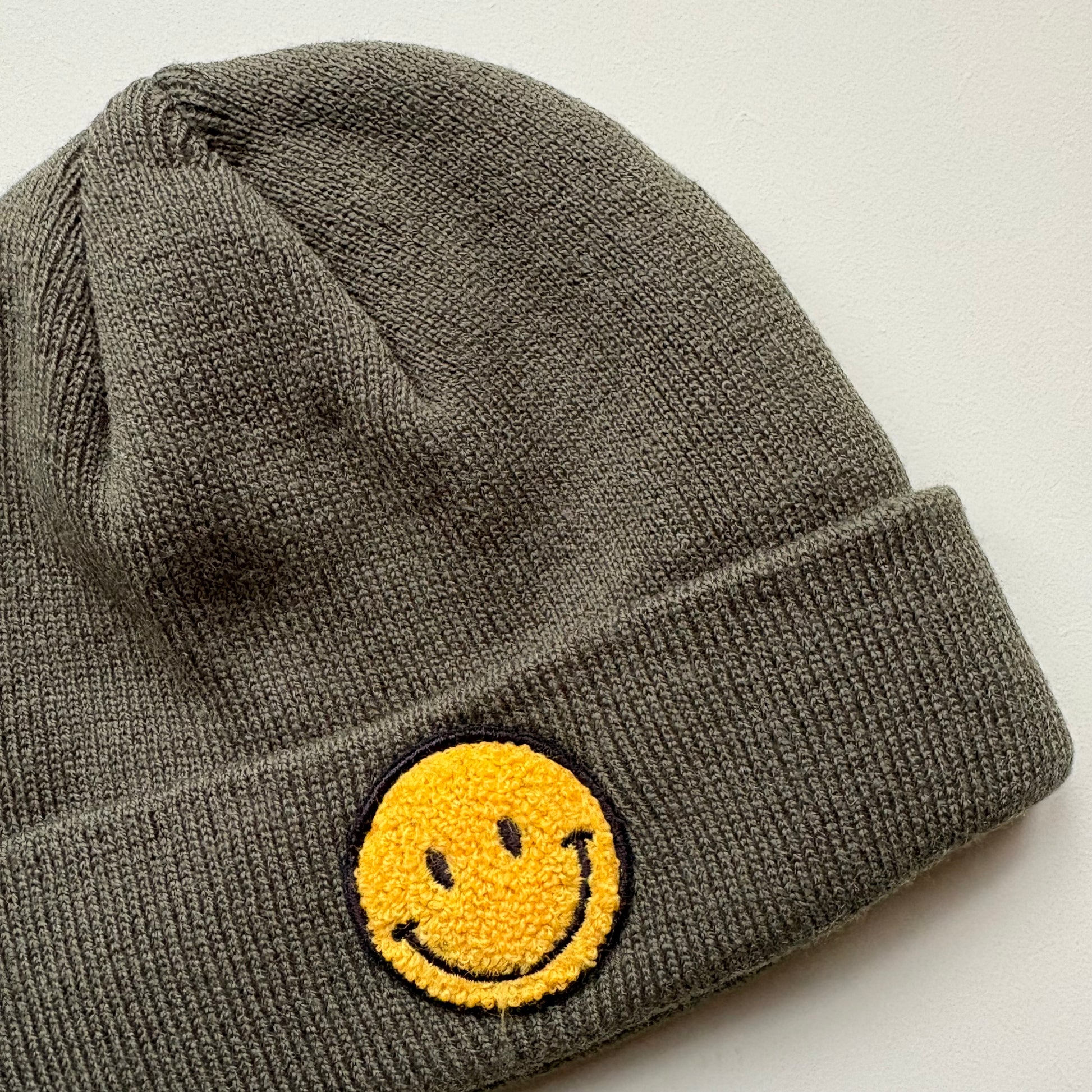 yellow embroidered smiley face detail on knit beanie