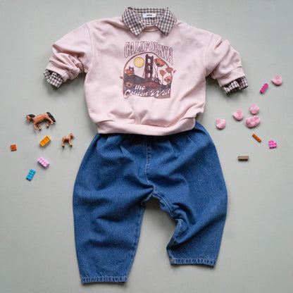 Pink sweatshirt with 'California, THE GOLDEN WEST' graphic design, brown check shirt and blue jeans