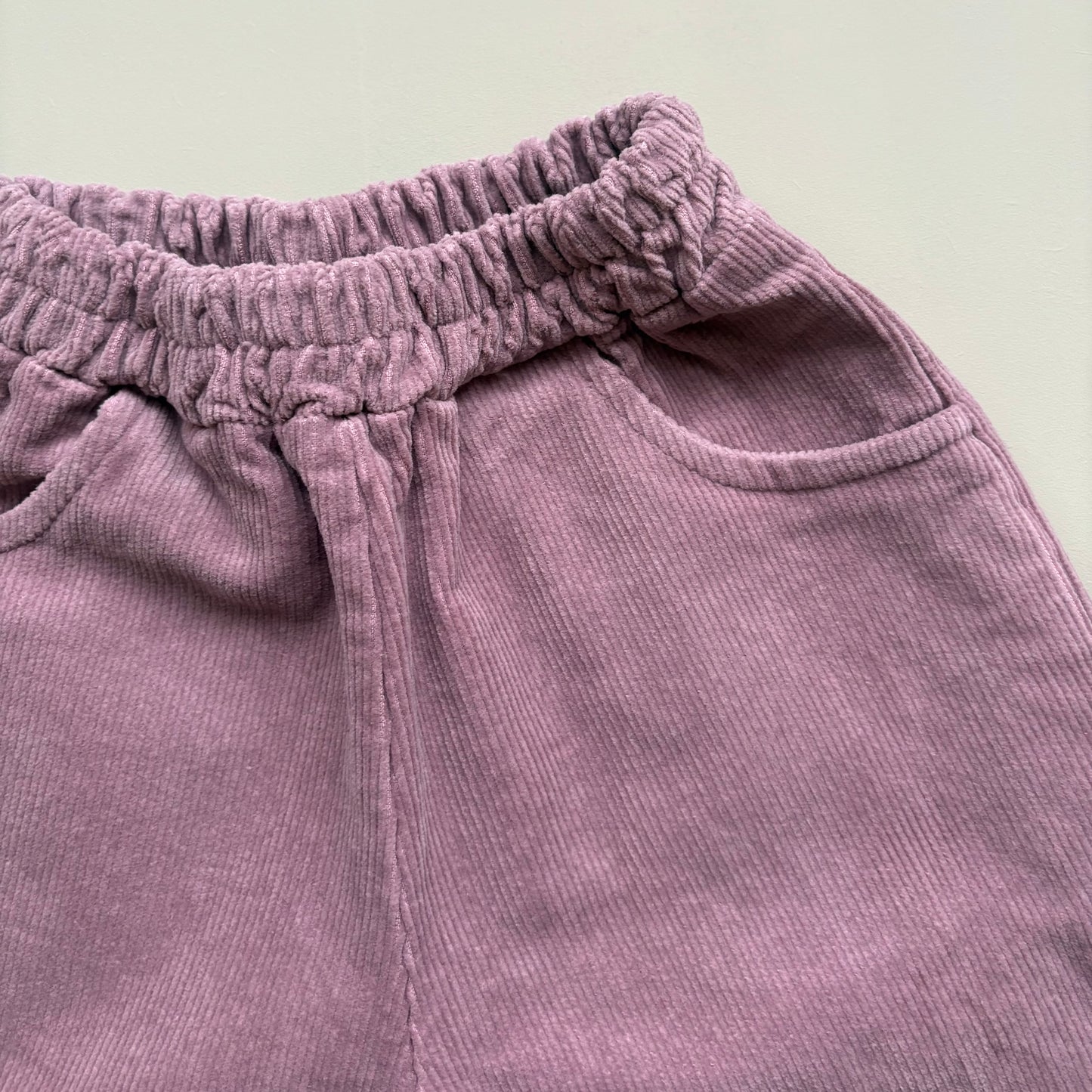 corduroy texture detail in lilac cotton trousers